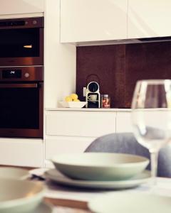 un tavolo con un piatto e un bicchiere di vino di THE RIVERSIDE LODGE Cozy and spacious apartment a Girona