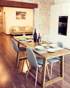 un soggiorno con tavolo e sedie in legno di THE RIVERSIDE LODGE Cozy and spacious apartment a Girona