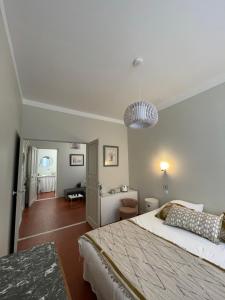 una camera con un grande letto e una luce a ciondolo di La villa des Amandiers a Hyères
