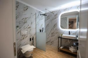 bagno con servizi igienici, lavandino e specchio di Vila Kace a Korçë