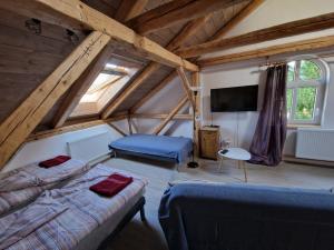 a attic room with two beds and a tv at Apartmán U kostela in Semily