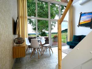 a living room with a table and chairs and a large window at Domki Adamus in Kudowa-Zdrój