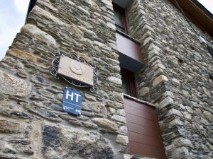 a sign on the side of a stone building at El Corral de Baró in Espot