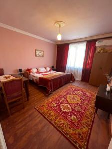 1 dormitorio con cama, mesa y alfombra en Гостевой дом en Nor Geghi