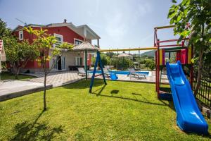 een speeltuin met een glijbaan in een tuin bij Villa Valerija in Srinjine