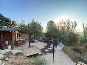 a backyard with a wooden deck and a house at Bit cabin near the airport in Kefar Daniyyel