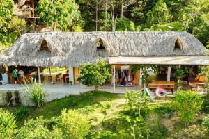 a house with a straw roof with a garden at The Fort Hostel in Don Diego