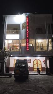 Bikash Bhawan Lodge في سيليغري: سيارة متوقفة أمام مبنى في الليل