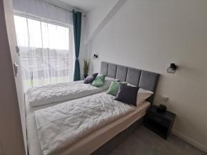 two beds in a room with a window at Apartament Apres Ski in Karpacz