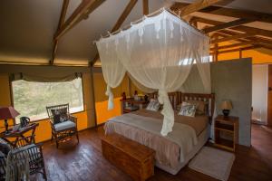 a bedroom with a bed with a canopy at Lion Tree Top Lodge in Guernsey Nature Reserve