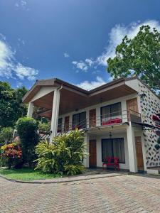 un bâtiment avec un banc rouge devant lui dans l'établissement Brillasol Airport Hotel, à Alajuela