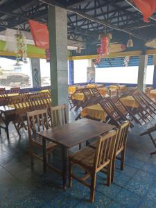 uma sala de jantar com mesas e cadeiras de madeira em Playa El Obispo E La Marea building La Libertad em La Libertad