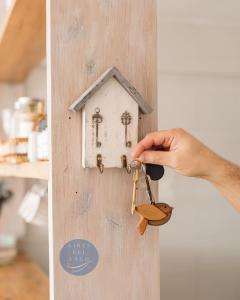 a hand unlocking a door with a house key at Aires del Lago in San Carlos de Bariloche