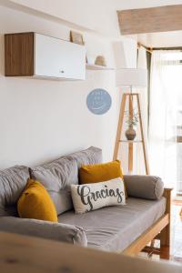 - un canapé gris avec des oreillers jaunes dans le salon dans l'établissement Aires del Lago, à San Carlos de Bariloche