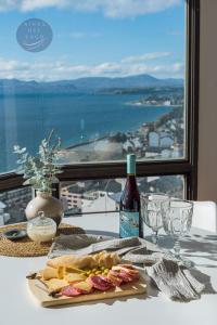 uma mesa com um prato de comida e uma garrafa de vinho em Aires del Lago em San Carlos de Bariloche