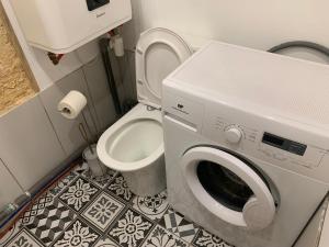 a bathroom with a washing machine and a toilet at chambre avec salle de bain et cuisine privée centre ville historique avec climatisation et patio in Bordeaux