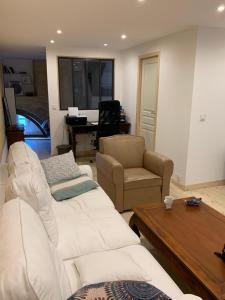 a living room with white couches and a table at chambre avec salle de bain et cuisine privée centre ville historique avec climatisation et patio in Bordeaux
