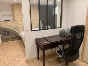 a desk with a mirror and a chair in a room at chambre avec salle de bain et cuisine privée centre ville historique avec climatisation et patio in Bordeaux +2 photos