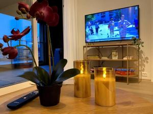 two candles on a table in a living room with a television at Divine Seaview Terrace in Sandnes