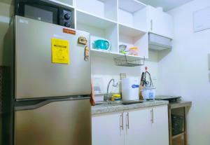 un frigorifero in acciaio inossidabile in una cucina con mobili bianchi di Hantowah's Crib - Southwoods a San Pedro