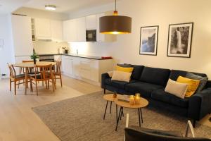 ein Wohnzimmer mit einem schwarzen Sofa und einem Tisch in der Unterkunft Divine Seaview Terrace in Sandnes