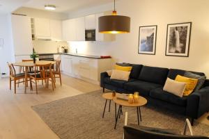 a living room with a black couch and a table at Divine Seaview Terrace in Sandnes