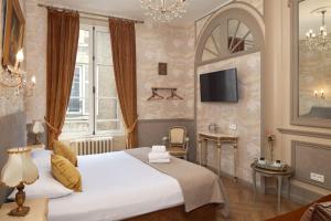 Cette chambre comprend un grand lit et une télévision. dans l'établissement Hôtel De France Et De Guise, à Blois