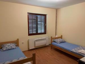 a room with two beds and a window at Hostel Drenak in Gornje Rataje