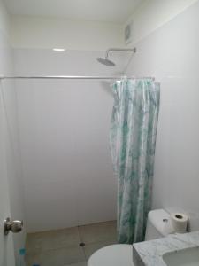 a bathroom with a toilet and a shower curtain at Habitación nueva para persona sola o pareja in Lima