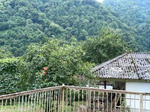 a house with a wooden fence and a tree at Mountain Heaven 