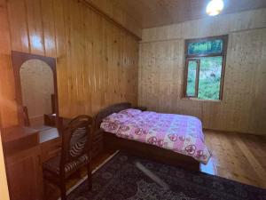 a small bedroom with a pink bed and a chair at Mountain Heaven 