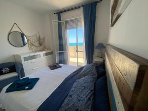 a bedroom with a bed with a view of the ocean at ATTICO VISTA MARE in Misano Adriatico