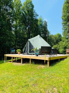 ein Zelt auf einer hölzernen Rampe mit einem Tisch in der Unterkunft Wildwood Heart Farm 