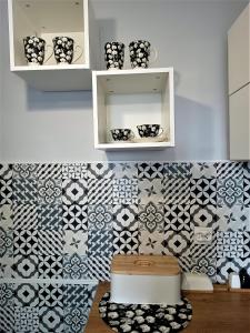 a kitchen with black and white tiles on the wall at Bursztynowy Apartament in Tarnowskie Góry