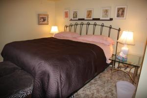 a bed in a bedroom with two lamps and a table at O'Brien House in Kingston