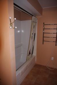 a bathroom with a bath tub with a shower curtain at O'Brien House in Kingston