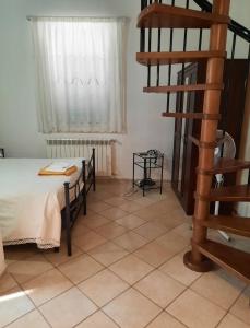 a bedroom with a bed and a spiral staircase at Agriturismo val martina in Scarlino
