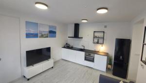 a kitchen with a large flat screen tv on the wall at Laguna24 Jezioro Żywieckie Klimatyzowany apartament 40 m2 in Zarzecze