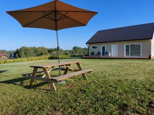 una mesa de picnic con una sombrilla en un patio en Oruheina Bungalow 