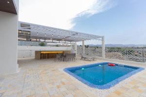 einen Pool auf einer Terrasse mit einem Tisch und Stühlen in der Unterkunft Horizon Villa in Qurayyah