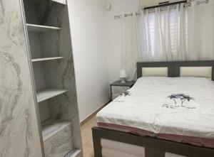 a bedroom with a bed and a book shelf at Sonego suite in Acre