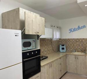 a kitchen with a refrigerator and a microwave in it at Sonego suite in Acre