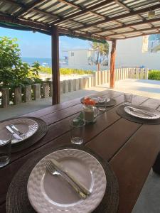 a wooden table with plates and utensils on it at Casa Lucia Beachfront Puerto Morelos in Puerto Morelos