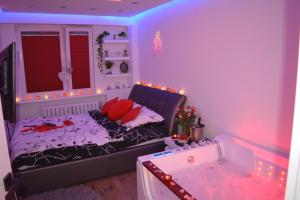 a room with a bed and a tub in it at Jacuzzi Apartament in Toruń