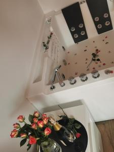 um quarto com um lavatório com um prato e flores em Jacuzzi Apartament em Toruń