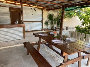 einen Holztisch und Bänke auf einer Terrasse in der Unterkunft Casa Lucia Beachfront Puerto Morelos in Puerto Morelos