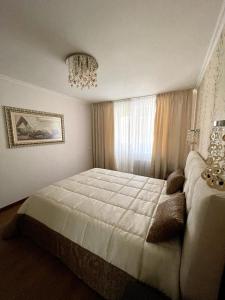 a bedroom with a large bed and a chandelier at Marius Homestay in Chişinău