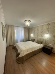 a bedroom with a large bed and a chandelier at Marius Homestay in Chişinău