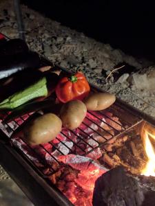 a bunch of vegetables are cooking on a grill at Desert's Edge Eco Tent in Arad