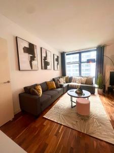 uma sala de estar com um sofá e uma mesa em Spacious One Bed Apartment Near Canary Wharf with SofaBed em Londres